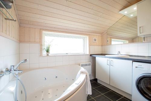 a bathroom with a tub and a window and a sink at Resort 2 Sea Lodge C 65 in Großenbrode