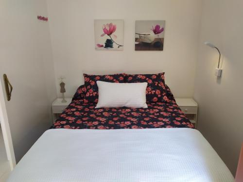 a bedroom with a bed with a flower patterned pillow at Canoa in Torrox Costa