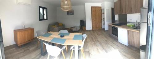 une cuisine avec une table et des chaises dans une pièce dans l'établissement Villa à 900 m de la plage de Lozari, à Belgodère