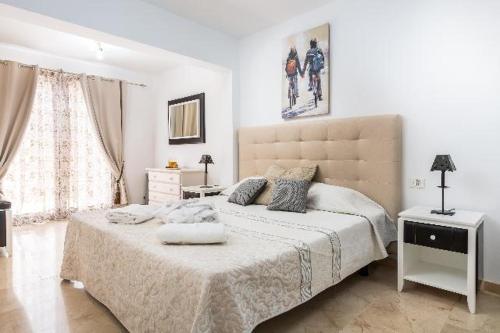 a white bedroom with a large bed with a large headboard at Casa Virgo in Adeje