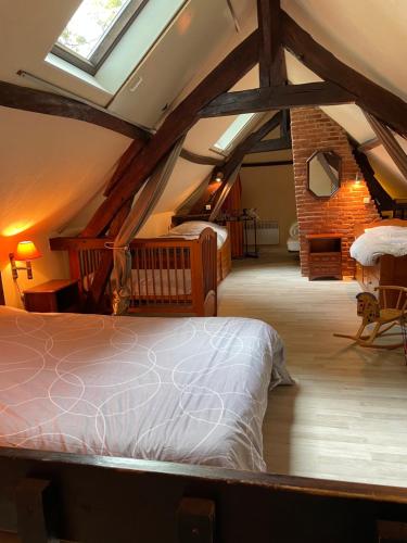 een slaapkamer met een groot bed op zolder bij Le Caux'gîte in Bretteville-du-Grand Caux