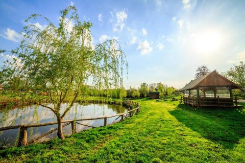 een park met een tuinhuisje naast een meer bij Pokoje Gościnne Butryny in Butryny