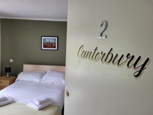 a bedroom with a bed and a sign that readsanship at The Flying Horse in Ashford