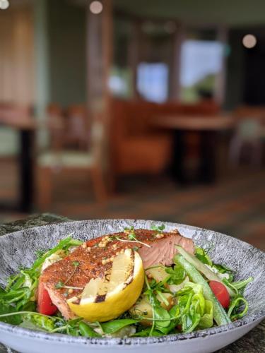 a plate of food with a salad with meat and a banana at Isle Of Mull Hotel and Spa in Craignure