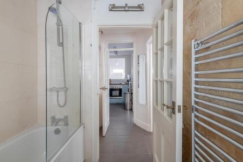 uma casa de banho com uma cabina de duche ao nível do chão e uma banheira em Ainslie's Apartment Belvedere em Bath