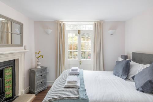 um quarto branco com uma cama e uma lareira em Ainslie's Apartment Belvedere em Bath