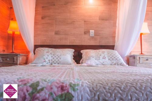 a bedroom with a large bed with two pillows at Hotel Ferrugem Eco Village in Garopaba