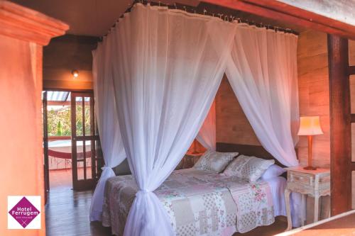 a bedroom with a bed with a canopy at Hotel Ferrugem Eco Village in Garopaba
