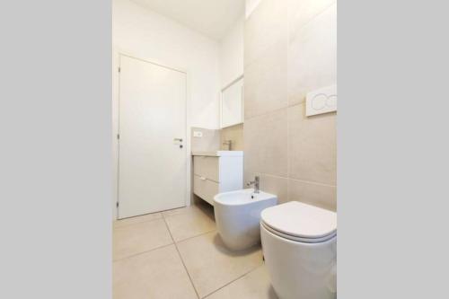 a white bathroom with a toilet and a sink at DELTA D Piazza Marina- 50 MT dal mare - Immobil Relax in Lido di Jesolo