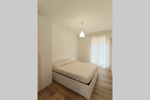 a white bedroom with a bed and a window at DELTA D Piazza Marina- 50 MT dal mare - Immobil Relax in Lido di Jesolo
