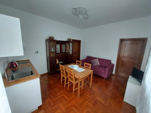 eine Küche und ein Wohnzimmer mit einem Tisch und einem lila Sofa in der Unterkunft Gli Oleandri B&B in Vaiano