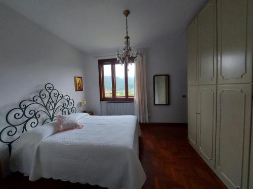 ein Schlafzimmer mit einem weißen Bett und einem Kronleuchter in der Unterkunft Gli Oleandri B&B in Vaiano