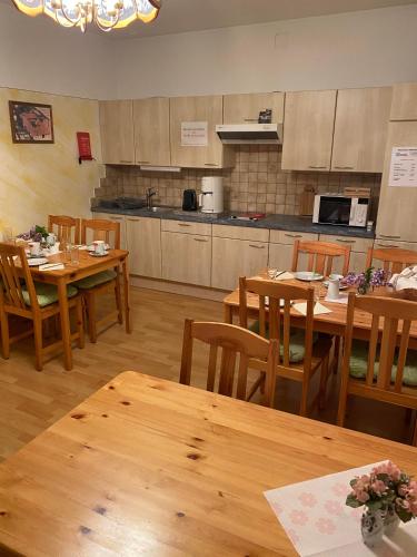 a dining room with wooden tables and a kitchen at Gästehaus Fischer Rohrendorf in Rohrendorf bei Krems
