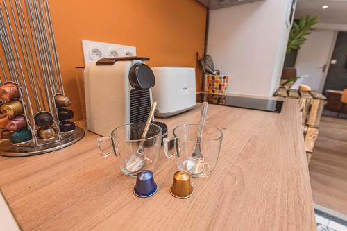a kitchen counter with three empty glasses on it at Gîtes Sérénaé avec vue sur rivière in Val de Vesle