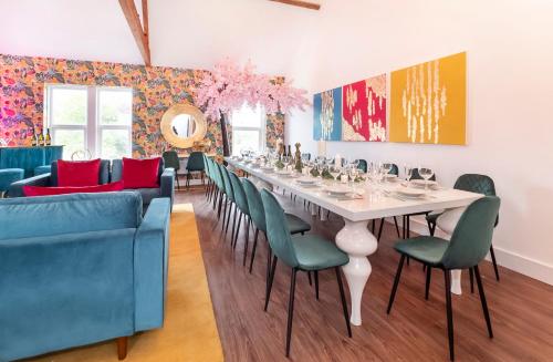 a dining room with a long white table and green chairs at Innvigour Bespoke House with Free Parking for 3 Cars in York