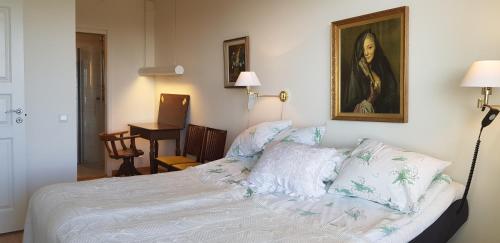 1 dormitorio con 1 cama y un retrato de una mujer en Snäck Apartment floor 11 sea view, en Visby