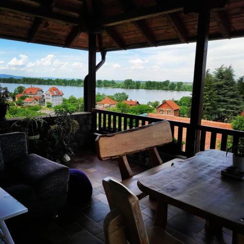 a porch with a bench and a view of a lake at HostelChe Guest House in Smederevo