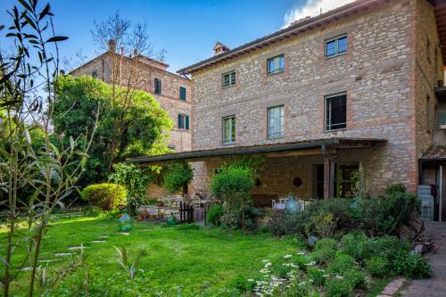 ein altes Steinhaus mit einem Hof davor in der Unterkunft Locanda Quattro Vesta in San Casciano dei Bagni
