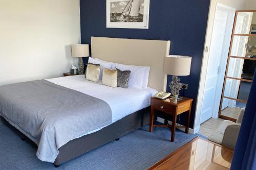 a bedroom with a large bed and a table with a phone at Haven Hotel in Poole