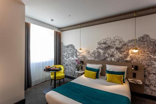 En eller flere senge i et værelse på Nemea Appart Hotel Paris Levallois