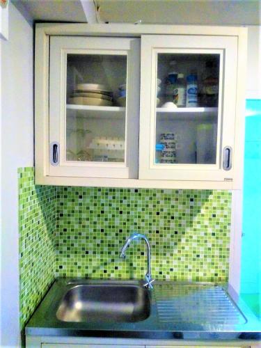 a kitchen with a sink and white cabinets at Sun on Hin Nam in Hua Hin
