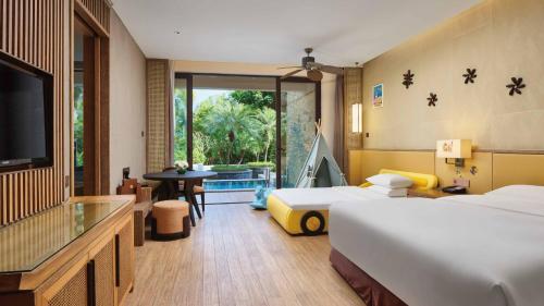 a hotel room with two beds and a television at Crowne Plaza Hailing Island by IHG in Yangjiang