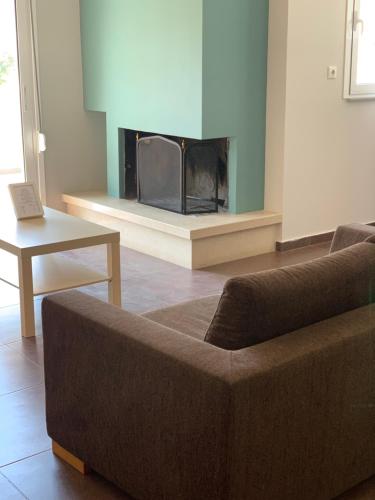 a living room with a couch and a fireplace at Alkistis Hotel in Diakopto