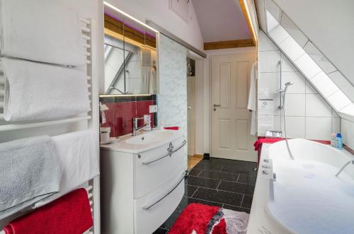a bathroom with a sink and a tub and a toilet at Flair Ferienwohnung Lilie in Stockach