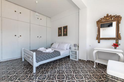 sypialnia z łóżkiem i lustrem w obiekcie Thimisi w mieście Skopelos