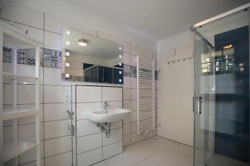 a white bathroom with a sink and a shower at Strandvilla Scholle - Dorsch Wohnung 02 in Boltenhagen