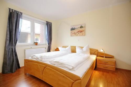 a bedroom with a bed with white sheets and a window at Malaga Wohnung 3 in Boltenhagen