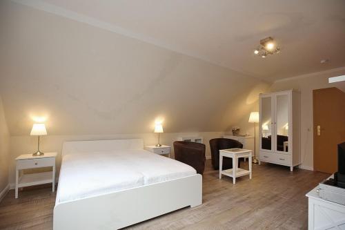 a bedroom with a white bed and a living room at Strandvilla Krabbe Wohnung 14 in Boltenhagen