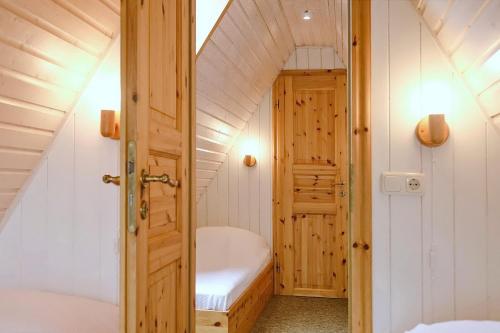 a small attic room with a bed and a door at An der Steilküste Finnhütte 04 in Boltenhagen