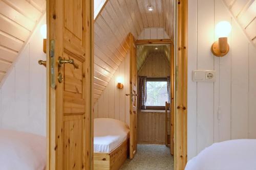 a small room with two beds and a door at An der Steilküste Finnhütte 04 in Boltenhagen