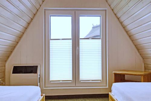 a room with two beds and a window at An der Steilküste Finnhütte 05 in Boltenhagen