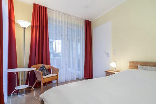 een slaapkamer met een bed, een tafel en een raam bij Dünenblick Wohnung 35 in Boltenhagen