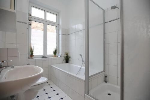 a white bathroom with a tub and a sink at Villa Triton Wohnung 01 in Boltenhagen