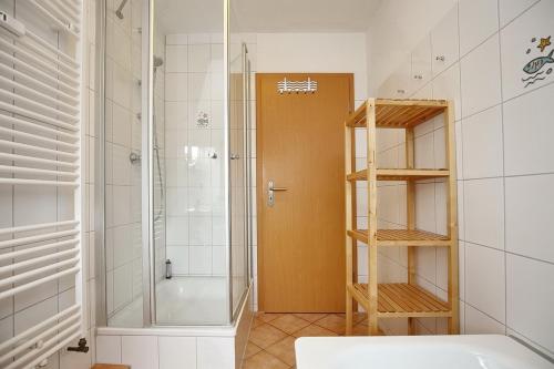 een badkamer met een douche en een glazen deur bij Villa Triton Wohnung 05 in Boltenhagen