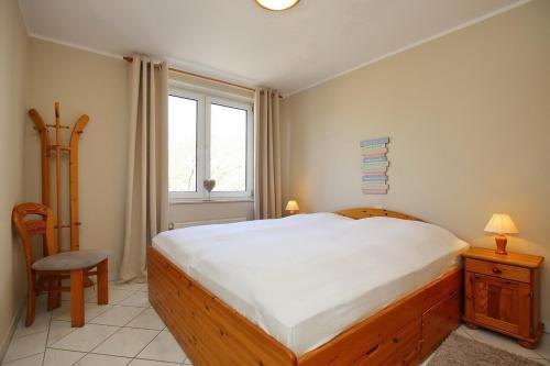 a bedroom with a large bed and a window at Sünnslag Wohnung 092 in Boltenhagen