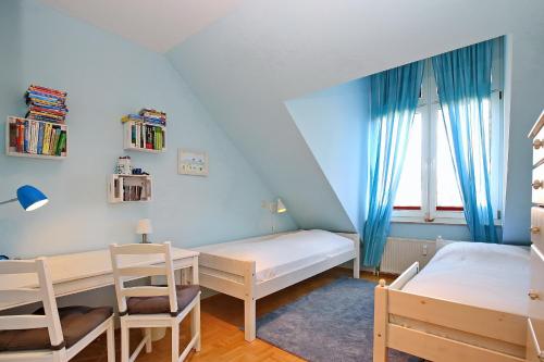 a bedroom with a bed and a desk and a table at Sünnslag Ostsee-Perle Wohnung 044 in Boltenhagen