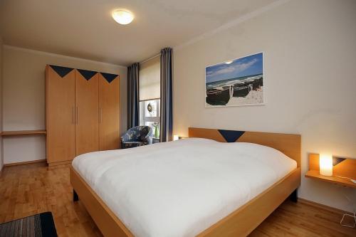 a bedroom with a large white bed in a room at Likedeeler Wohnung 01 in Boltenhagen