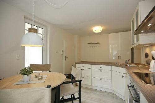 a kitchen with a table and some chairs in it at Strandvilla Scholle - Lachs Wohnung 01 in Boltenhagen