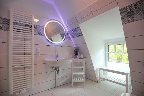 a bathroom with a sink and a mirror at Strandvilla Scholle - Scholle Wohnung 05 in Boltenhagen