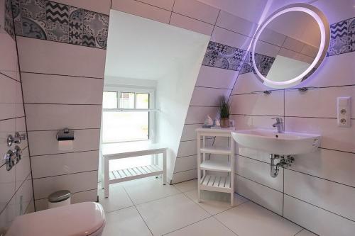 a bathroom with a sink and a mirror at Strandvilla Scholle - Aal Wohnung 06 in Boltenhagen