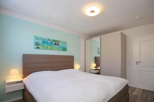 um quarto com uma grande cama branca num quarto em Sünnslag Wohnung 063 em Boltenhagen