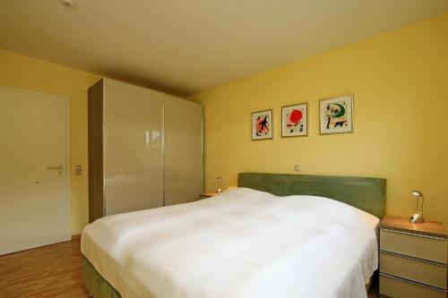 a bedroom with a large white bed and yellow walls at Goosbrink Wohnung 08 in Boltenhagen