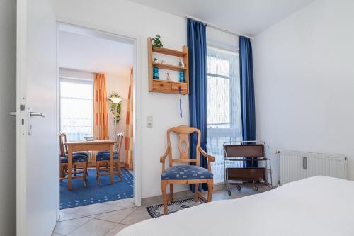 - une chambre avec un lit, une table et des chaises dans l'établissement Dünenblick Wohnung 33, à Boltenhagen