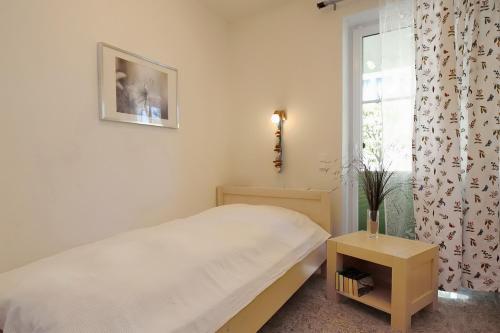 a small bedroom with a bed and a window at Strandvilla Niklot Wohnung 03 in Boltenhagen