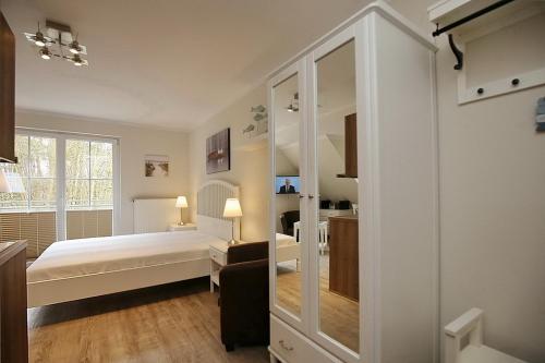 a bedroom with a bed and a large mirror at Strandvilla Krabbe Wohnung 11 in Boltenhagen