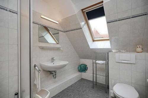 a white bathroom with a sink and a toilet at Strandvilla Krabbe Wohnung 11 in Boltenhagen